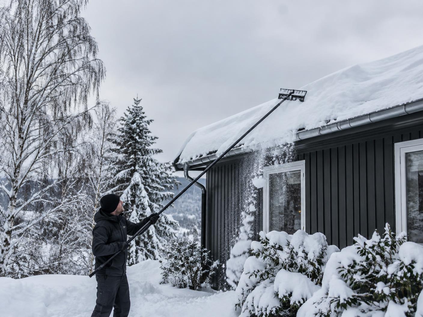 Takmåking med takrake fra bakken ved en norsk enebolig
